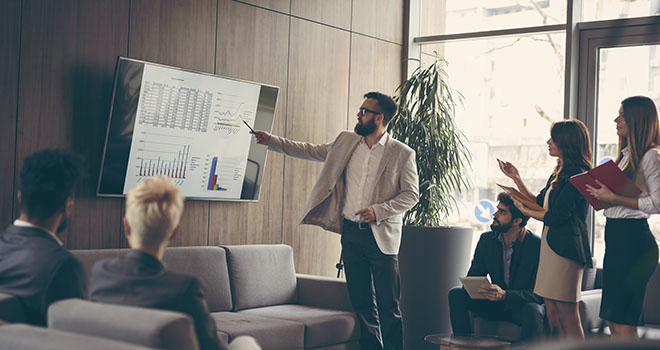 Training and development in a lobby around a presentation.